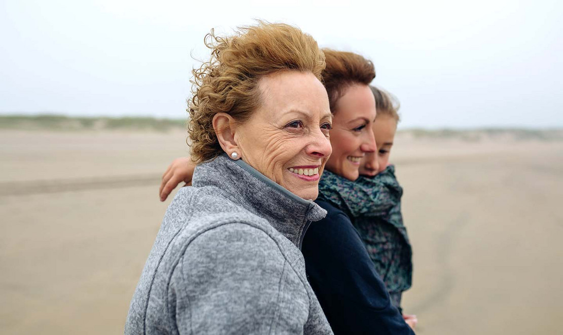 Frauen unterschiedlichen Alters stehen am Strand