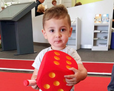 Ein kleiner Junge hält einen großen roten Schaumstoffwürfel und eine Packung SoVD-Seifenblasen in den Händen.