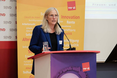 Frau spricht am Rednerpult in ein Mikrofon. 