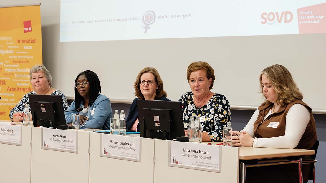 Fünf Frauen sitzen auf einem Podium. 